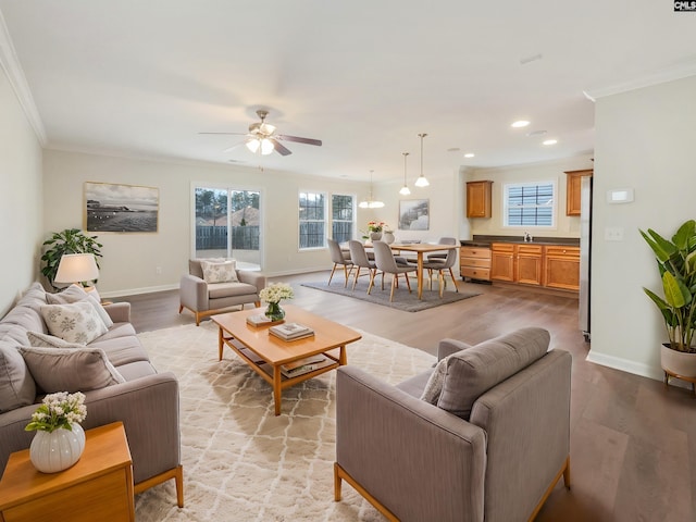 living room with crown molding, ceiling fan, hardwood / wood-style flooring, and a wealth of natural light