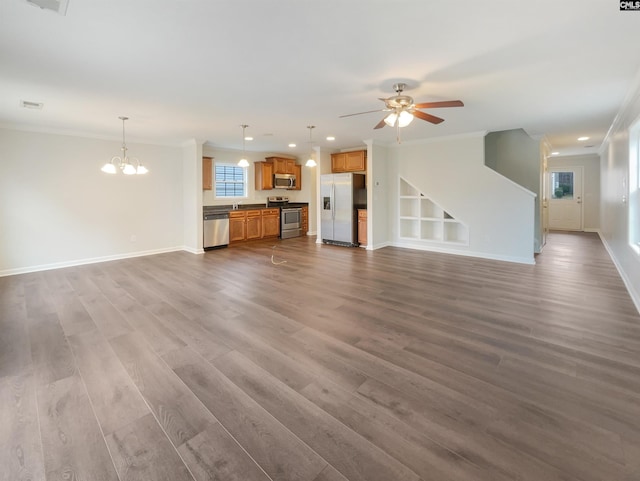 unfurnished living room with built in shelves, crown molding, ceiling fan with notable chandelier, and hardwood / wood-style floors