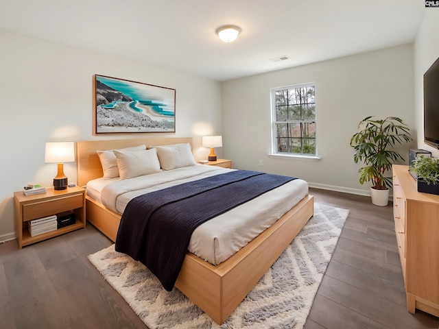 bedroom with dark hardwood / wood-style floors