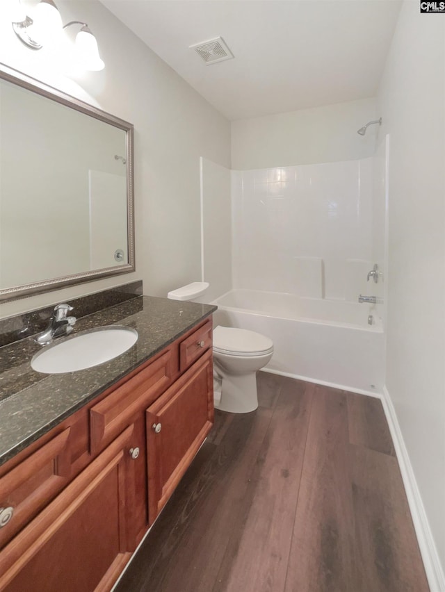 full bathroom featuring shower / washtub combination, hardwood / wood-style floors, vanity, and toilet