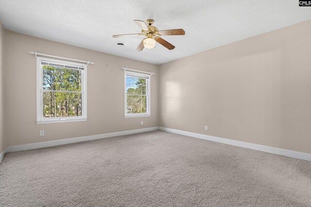 spare room with ceiling fan, a healthy amount of sunlight, and carpet flooring