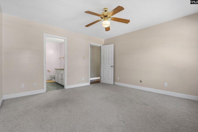 unfurnished bedroom with ceiling fan, ensuite bathroom, and light carpet