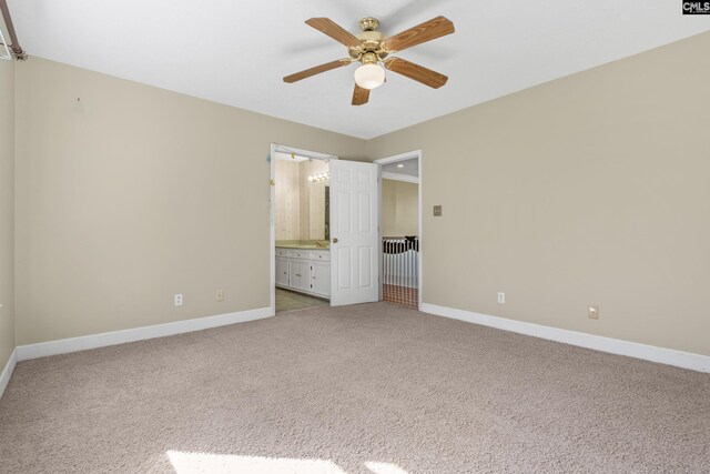 unfurnished bedroom with ensuite bathroom, carpet floors, and ceiling fan