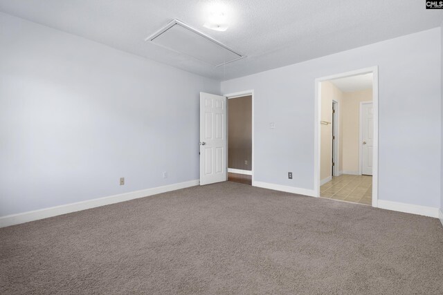 spare room featuring light carpet and a textured ceiling