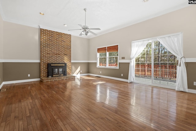 unfurnished living room with crown molding, wood-type flooring, and a brick fireplace