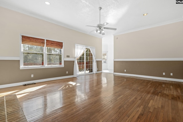 unfurnished living room featuring wood-type flooring, ornamental molding, and ceiling fan