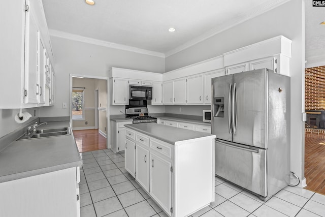 kitchen featuring white cabinetry, sink, light tile patterned floors, and appliances with stainless steel finishes