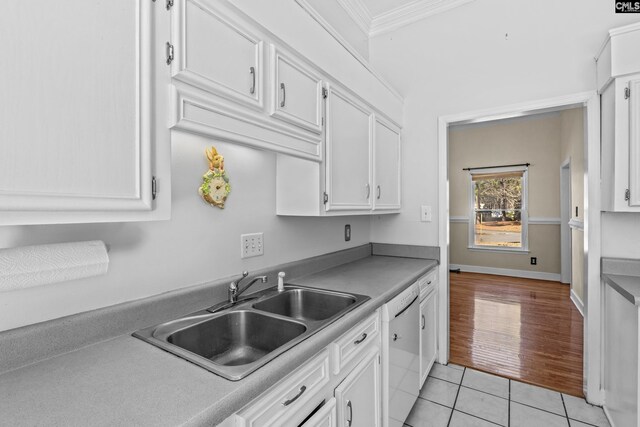 kitchen with light tile patterned flooring, sink, white cabinets, white dishwasher, and crown molding