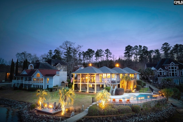 back house at dusk featuring an outdoor fire pit