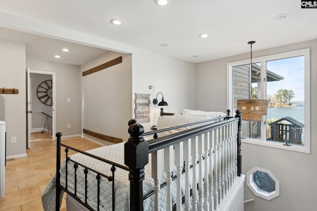 bedroom featuring a water view and multiple windows