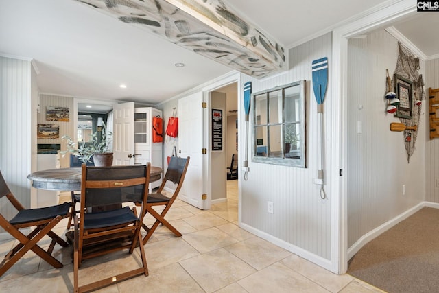 tiled dining space with ornamental molding and wood walls