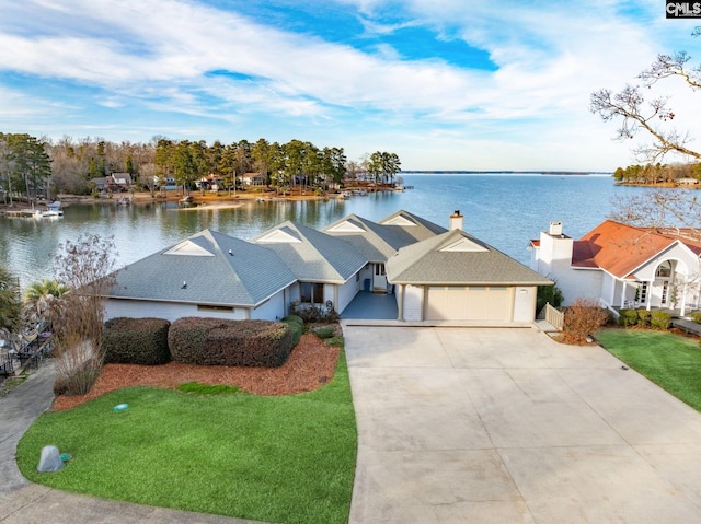 view of front facade with a garage, a front lawn, and a water view