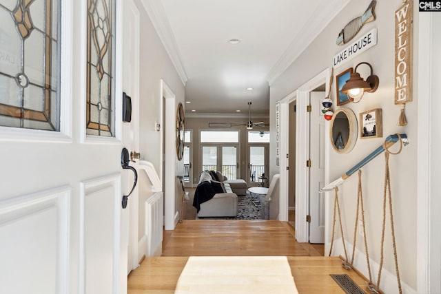 entrance foyer featuring crown molding, ceiling fan, and light wood-type flooring