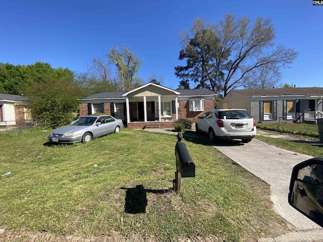 ranch-style house with a front yard and covered porch