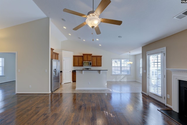 unfurnished living room featuring high vaulted ceiling, dark hardwood / wood-style flooring, and ceiling fan with notable chandelier