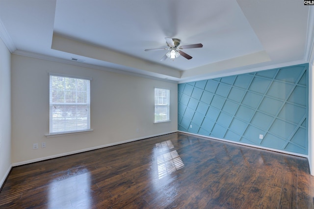 empty room featuring dark hardwood / wood-style floors, a healthy amount of sunlight, and a tray ceiling