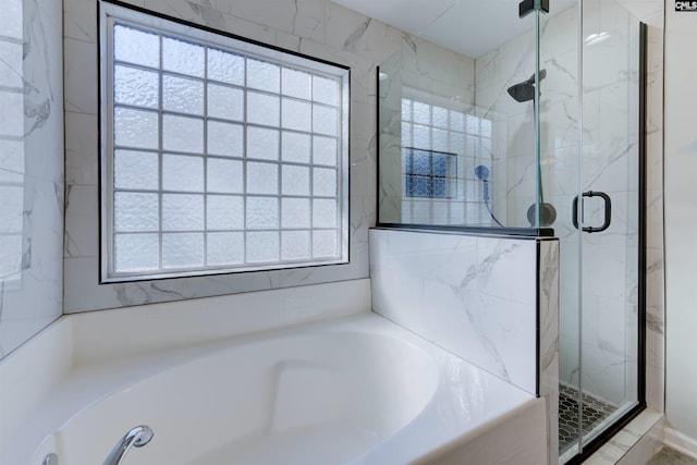 bathroom featuring independent shower and bath and a wealth of natural light