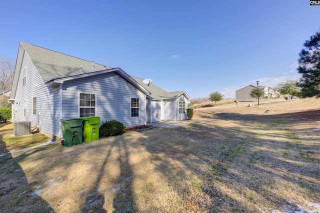 view of side of property featuring a yard and cooling unit