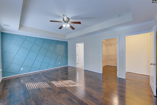 spare room with dark hardwood / wood-style flooring, a raised ceiling, and ceiling fan