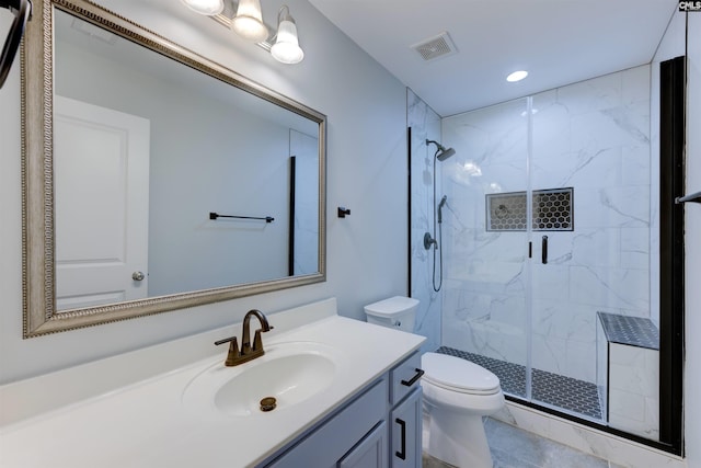 bathroom featuring vanity, a shower with shower door, and toilet