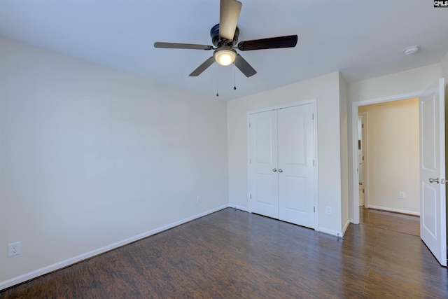 unfurnished bedroom featuring dark hardwood / wood-style floors, ceiling fan, and a closet