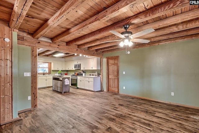 kitchen with appliances with stainless steel finishes, white cabinetry, sink, a center island, and light wood-type flooring