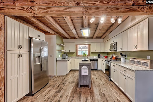 kitchen with wood ceiling, appliances with stainless steel finishes, light stone countertops, white cabinets, and beamed ceiling