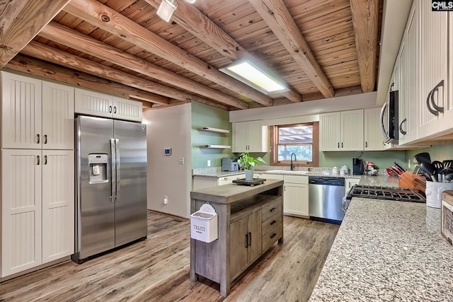 kitchen with sink, wood ceiling, appliances with stainless steel finishes, beam ceiling, and light stone countertops