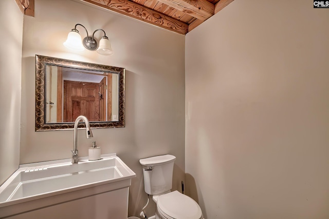 bathroom with beamed ceiling, vanity, wood ceiling, and toilet