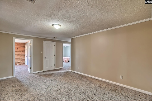 spare room featuring carpet floors, ornamental molding, a textured ceiling, and wood walls