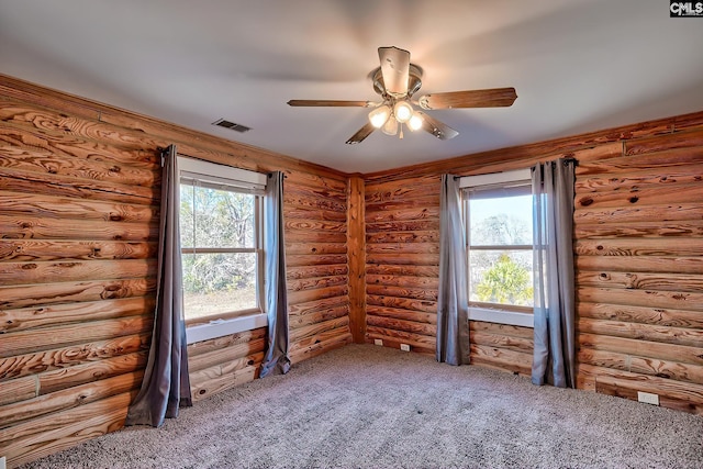 unfurnished room featuring log walls and plenty of natural light