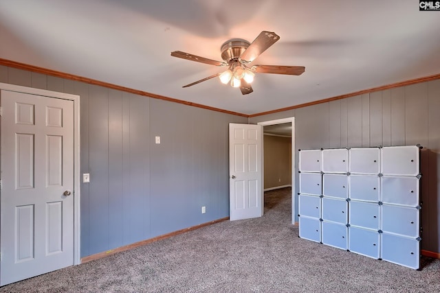 unfurnished bedroom with ornamental molding, ceiling fan, and carpet flooring