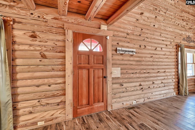 entrance foyer featuring wood ceiling, rustic walls, hardwood / wood-style floors, beam ceiling, and a wealth of natural light