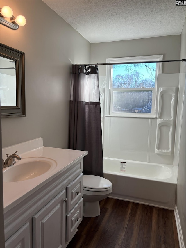 full bathroom featuring hardwood / wood-style flooring, vanity, toilet, shower / bathtub combination with curtain, and a textured ceiling