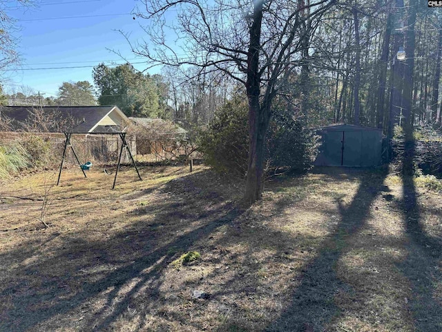 view of yard featuring a playground and a storage unit