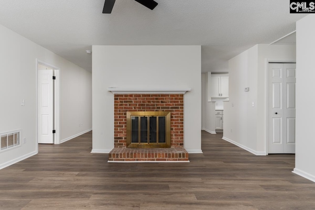 unfurnished living room featuring ceiling fan, dark wood-type flooring, and a fireplace