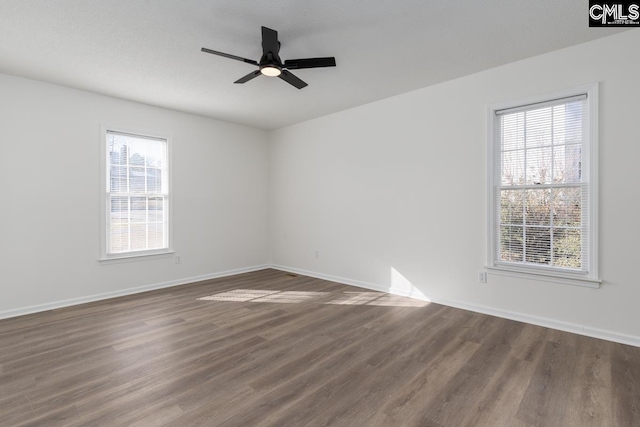 spare room featuring dark hardwood / wood-style flooring, plenty of natural light, and ceiling fan