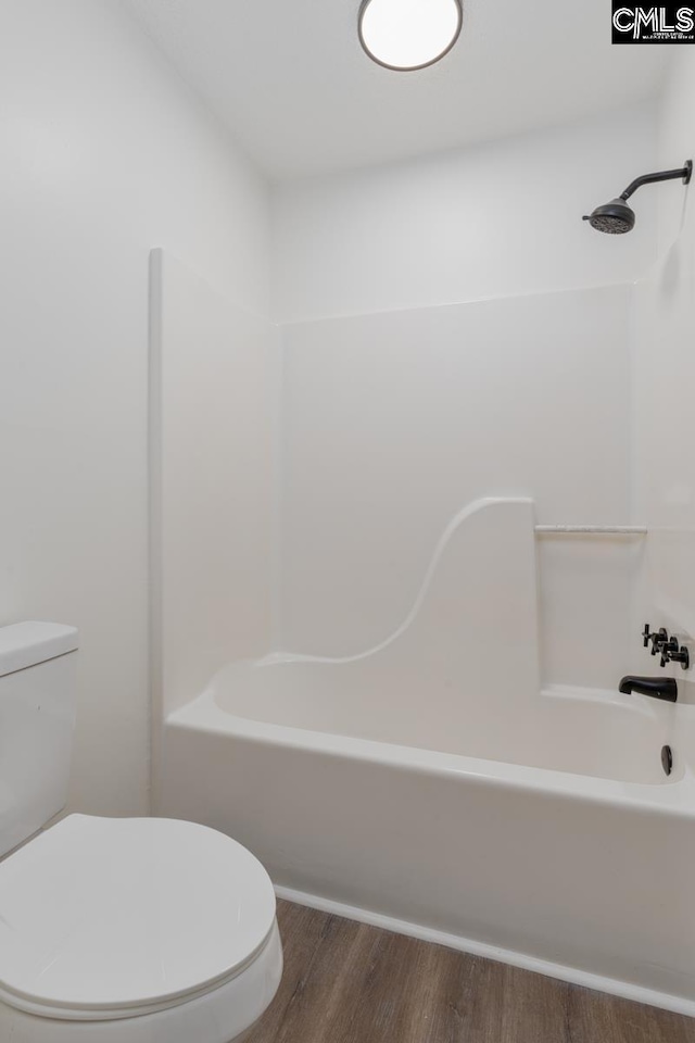 bathroom with wood-type flooring, shower / bathing tub combination, and toilet