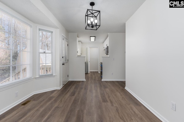 interior space with dark wood-type flooring and a notable chandelier