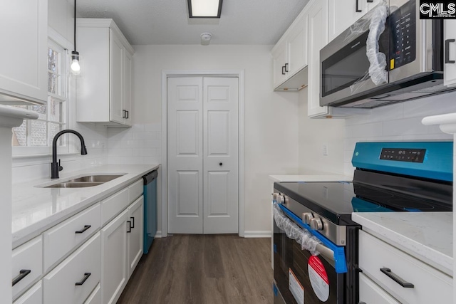 kitchen featuring sink, white cabinetry, stainless steel appliances, dark hardwood / wood-style floors, and decorative light fixtures