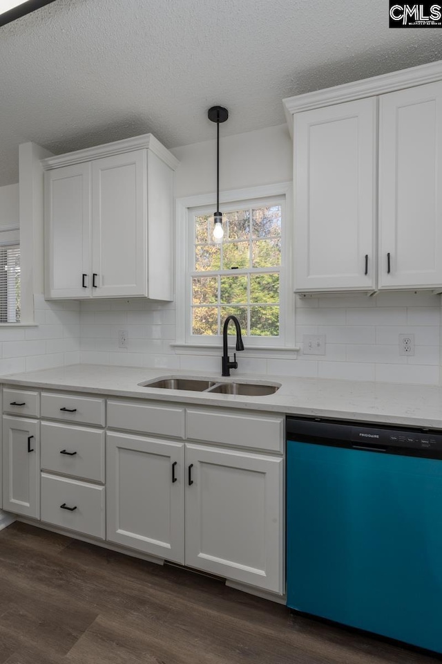 kitchen featuring sink, white cabinetry, hanging light fixtures, a textured ceiling, and dishwashing machine