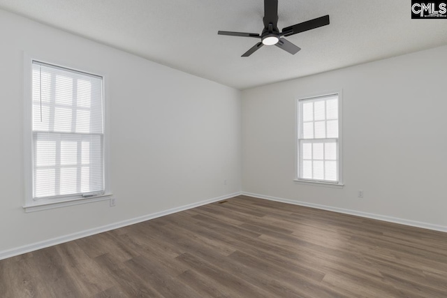 spare room featuring dark wood-type flooring and ceiling fan