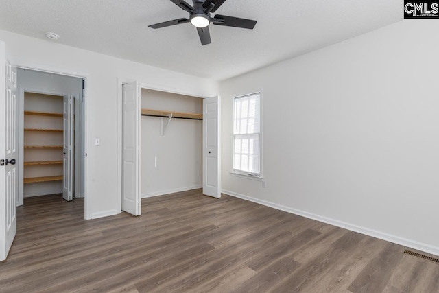 unfurnished bedroom featuring dark wood-type flooring and ceiling fan