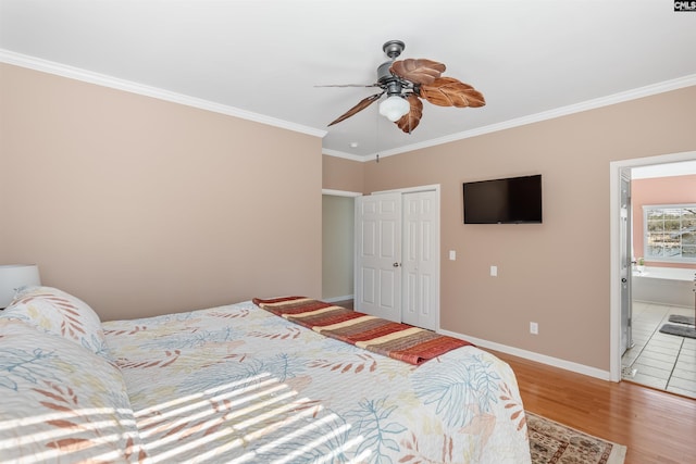 bedroom with connected bathroom, wood-type flooring, ornamental molding, a closet, and ceiling fan