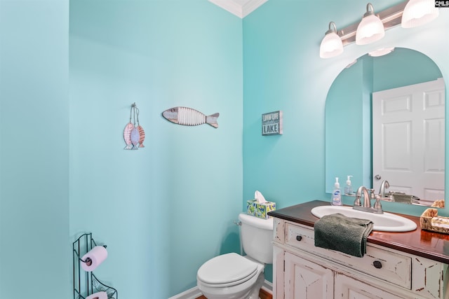 bathroom featuring vanity, crown molding, and toilet