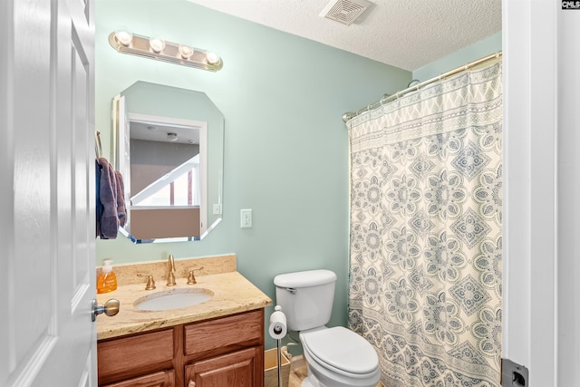 bathroom featuring vanity, a shower with shower curtain, a textured ceiling, and toilet