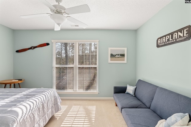 carpeted bedroom featuring a textured ceiling and ceiling fan