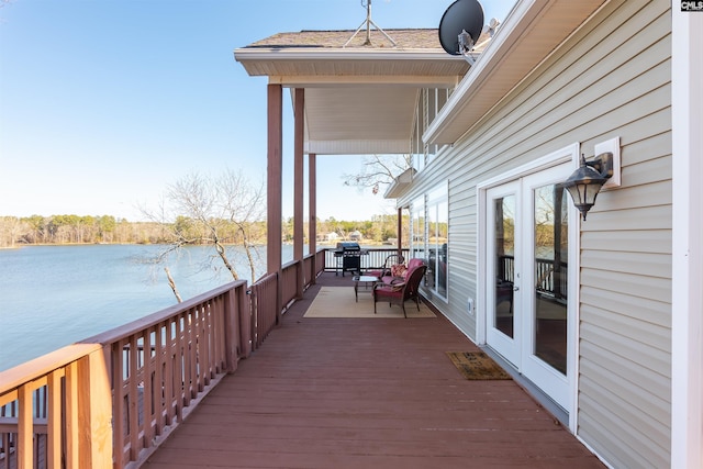 wooden terrace featuring a water view and french doors