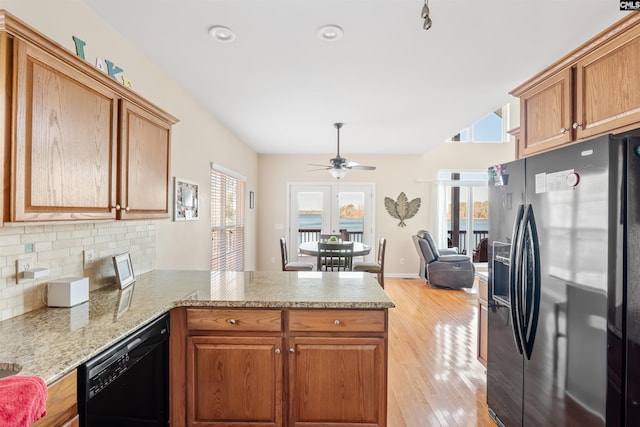 kitchen featuring tasteful backsplash, light wood-type flooring, kitchen peninsula, ceiling fan, and black appliances