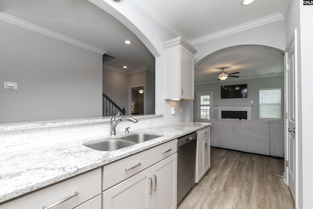 kitchen featuring sink, white cabinetry, black dishwasher, light stone counters, and ornamental molding